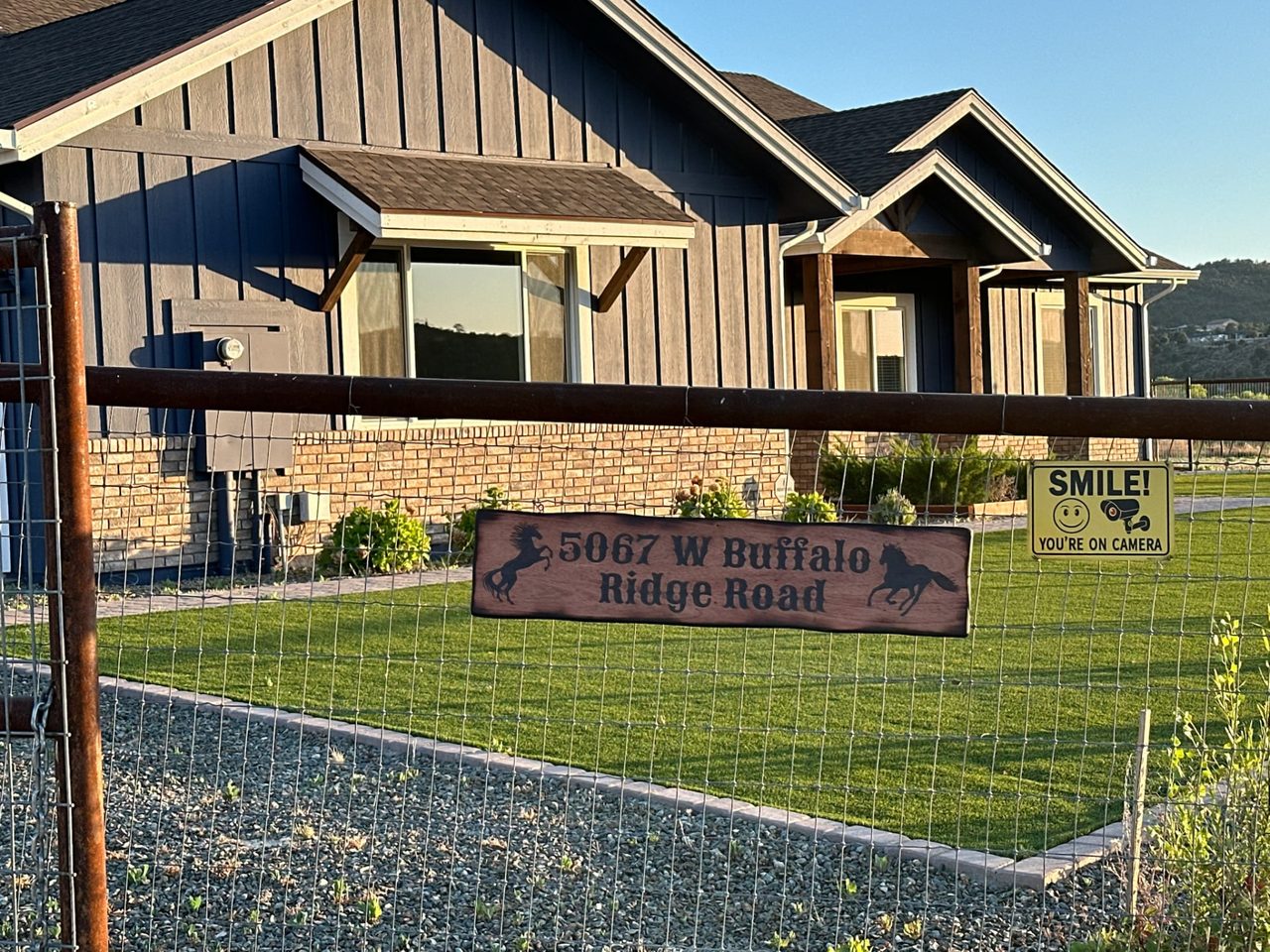 Front exterior of the Mindful Mavens LLC Retreat House with board-and-batten siding and mountain surroundings